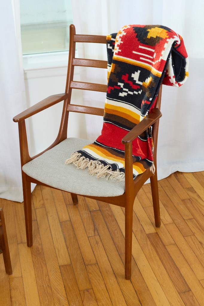 Armchair with Southwestern textile — texture, wood grain, bright studio light