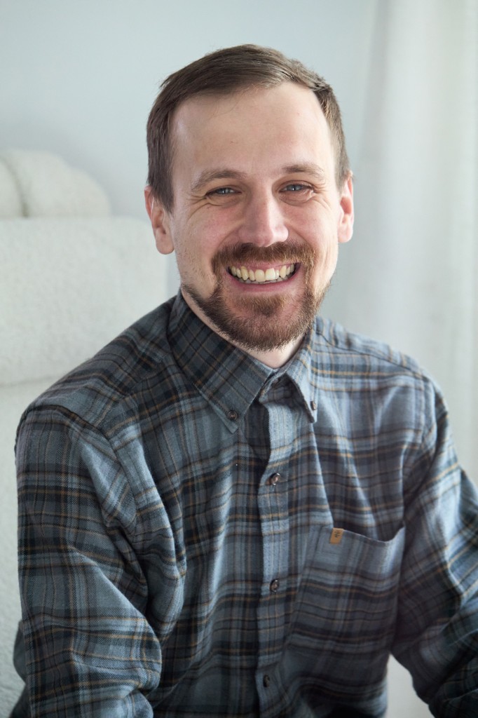 Environmental portrait — seated, professional, and at ease in the space